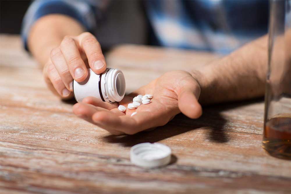 man pouring benzo tablets into hand