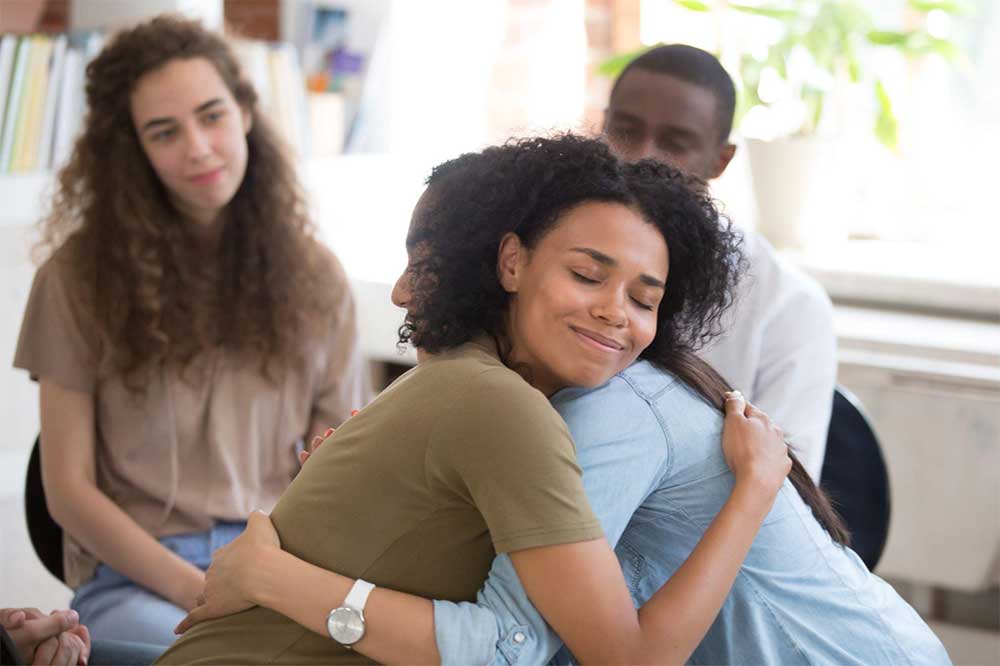 young woman hugging therapist