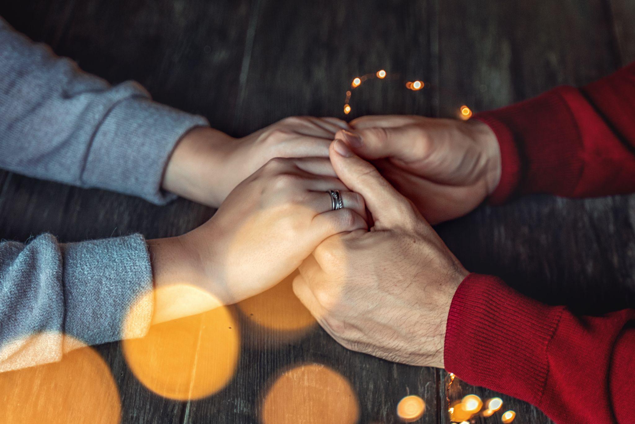 Man and woman hold hands on the background of New Year lights