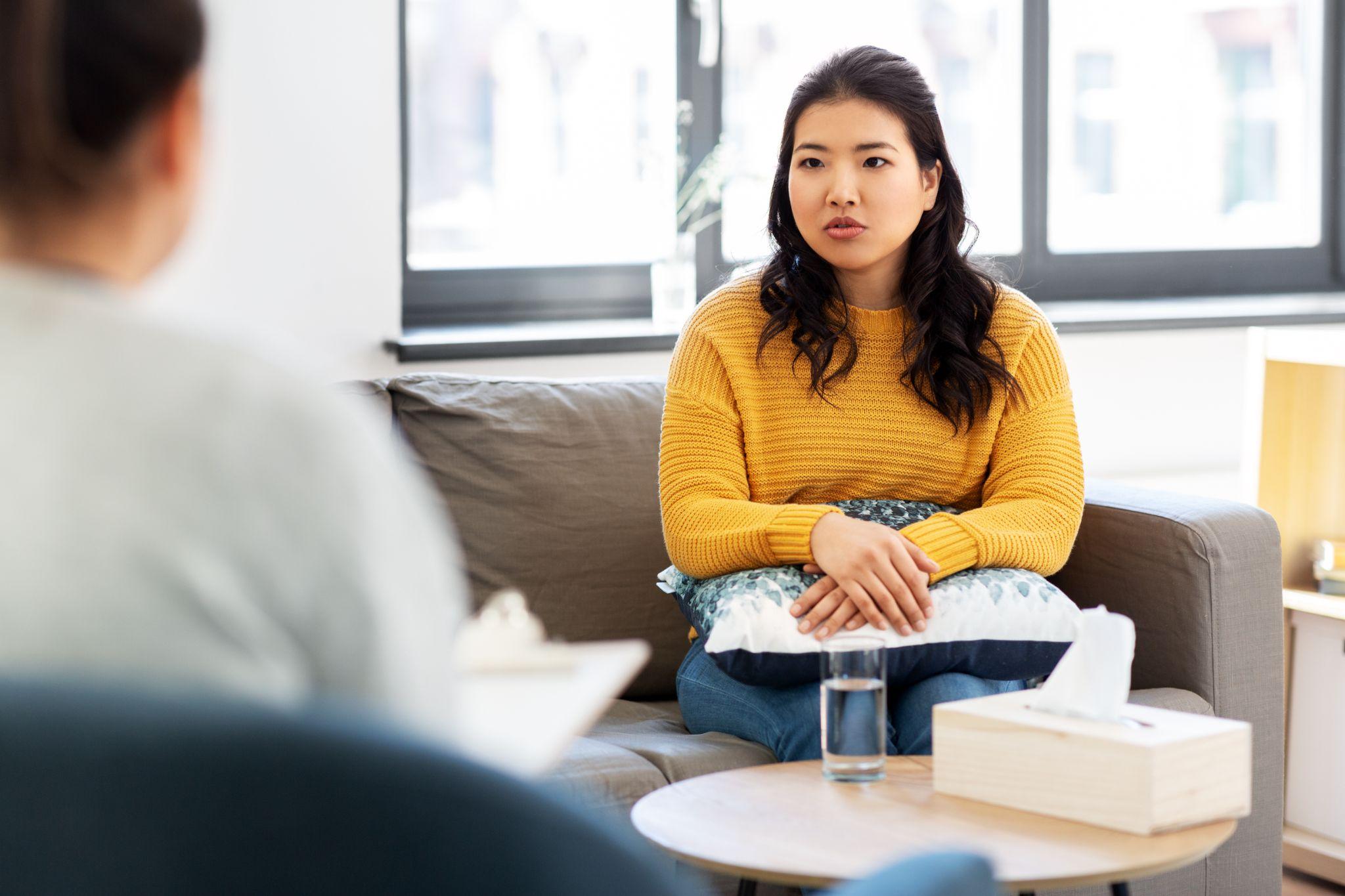 psychology and mental therapy concept - young asian woman patient and psychologist at psychotherapy session