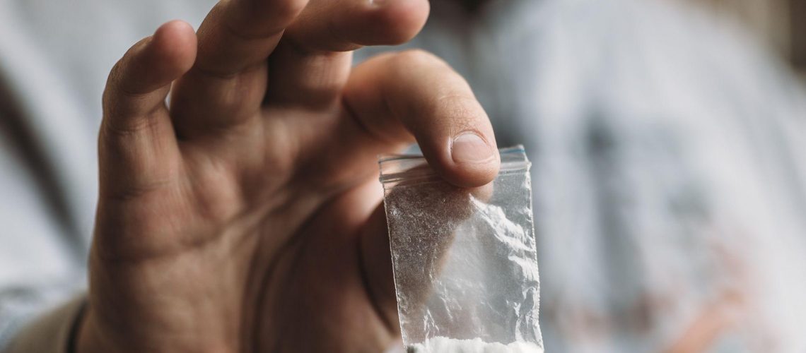 Man hand holding cocaine or other drugs